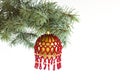 Christmas tree fir branch with hanging handmade craft new year toy ball pattern from red beads Royalty Free Stock Photo