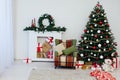Christmas tree with fireplace interior of white room new year decoration garland gifts Royalty Free Stock Photo