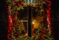 Christmas tree and fireplace seen through a wooden cabin window