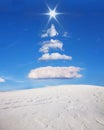 Christmas tree formed in the sky with clouds and sun. Royalty Free Stock Photo