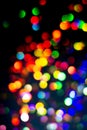 Christmas tree garland light. Colorful bokeh blurry decor on black background. Holiday wallpaper night glowing.