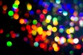 Christmas tree garland light. Colorful bokeh blurry decor on black background. Holiday wallpaper night glowing