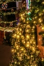 Christmas tree and garland outdoors on city street with bokeh lights strung across between buildings in Athens Greece Royalty Free Stock Photo