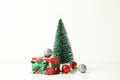Christmas tree, gift box and baubles on white background Royalty Free Stock Photo