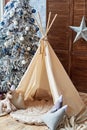 Christmas tree with gifts and wigwam in child room, copy space. Christmas decorations. Childen room interior with decorated play.