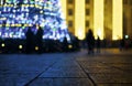 Christmas tree with glowing lights defocused. Paving slabs in foreground close up. Royalty Free Stock Photo