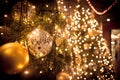 Christmas tree with gold ball and bokeh lights background. Xmas abstract close up with glowing decorations outdoors