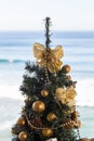 Christmas tree with gold decoration on waves of sea