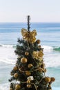 Christmas tree with gold decoration on waves of sea