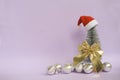 Christmas tree with golden bow and silver balls, Santa hat on a pink background . Christmas background Royalty Free Stock Photo
