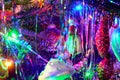 Christmas tree holiday background with garland, glass toys, balls, lights. Colorful decoration close-up in dark key.