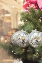 Christmas tree with holiday silver balls and lights with copy space on blurred bokeh background in interiors. Close up. Royalty Free Stock Photo