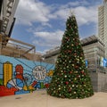 Christmas Tree and `Howdy Dallas` mural in front of Victory Plaza and the American Airlines Center in Dallas, Texas.