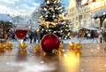 red  Christmas ball glass of wine and yellow garland light on wooden top in  street medieval Tallinn old town hall square holiday Royalty Free Stock Photo