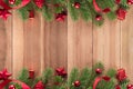 Christmas tree leaves with red ornaments on wood background Royalty Free Stock Photo