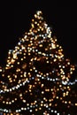 Christmas tree lights on black blurred background. Natural, festive bokeh lighting. Happy New Year and winter Holidays Royalty Free Stock Photo