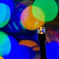 Christmas tree lights of a garland on a blurred background of light spots, close-up. Royalty Free Stock Photo