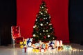 Christmas tree with lights garlands and new year gifts interior of the red room Royalty Free Stock Photo