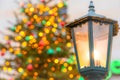 A Christmas tree with lights and a lamp post in front of it Royalty Free Stock Photo