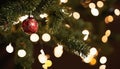 A Christmas tree with lights and a red ornament Royalty Free Stock Photo