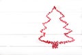 The Christmas tree is lined with an outline of red glittering hearts. Holiday concept