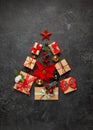 Christmas tree made from Christmas gifts and decorations on black background. Creative winter holiday concept. Flat lay Royalty Free Stock Photo