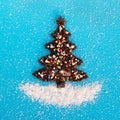 Christmas tree made from coffee beans and decorated, culinary sprinkling and coconut chips on a blue background, top view. Royalty Free Stock Photo