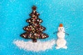 Christmas tree made from coffee beans and decorated culinary sprinkling and coconut chips on a blue background, top view Royalty Free Stock Photo