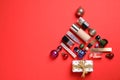 Christmas tree made of cosmetic products, accessories and baubles on red background, flat lay. Space for text Royalty Free Stock Photo