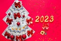 Christmas tree made of 100 dollar bills and House key, candles with the numbers 2023. Christmas decor of finance, savings, wealth Royalty Free Stock Photo