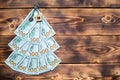 Christmas tree made of 100 dollar bills on wooden background with copyspace and House key. Christmas decor of finance, savings, Royalty Free Stock Photo