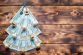 Christmas tree made of 100 dollar bills on wooden background with copyspace and House key. Christmas decor of finance, savings, Royalty Free Stock Photo