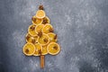 Christmas tree made of dried orange slices, decorated with star anise and cinnamon sticks on gray background, copy space Royalty Free Stock Photo