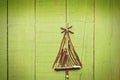 Christmas tree made from dry sticks on wooden, bright, green background.