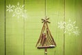 Christmas tree made from dry sticks on wooden, green background. Snow flaks image