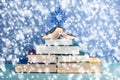 Christmas tree made of fancy books in multi-colored covers, decorated with a large blue snowflake.