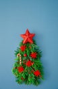 Christmas tree made of fir, thuja, cypress branches, red wooden snowflakes, star and sweets. Top view. Xmas greeting card mockup,