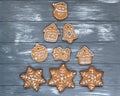 Christmas tree made with homemade gingerbread cookies on plate on gray wooden background. Snowflake, star, tree, snowman, Royalty Free Stock Photo