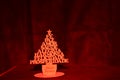 Christmas tree made of MDF wood with blurred red light. Studio\'s photo. Black background Royalty Free Stock Photo