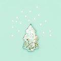 Christmas tree made with mold for the cookies and silver sparkling stars on blue background. Flat lay. winter concept Royalty Free Stock Photo