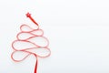 Christmas Tree made from Red satin ribbon with a star on the top on white wooden background. Xmas, winter, new year concept. Flat
