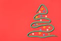Christmas tree made of shoe lace and different buttons on red background, flat lay. Space for text Royalty Free Stock Photo