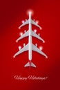 Christmas Tree Made of three Airplanes and decorative lights against a red background. Happy Holidays and Happy New Year