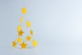 Christmas tree made of yellow stars decoration on white background. Minimal Christmas or New Year concept