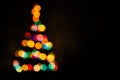 Christmas tree multicolored bokeh on dark background. Defocused multi colored lights. New Year, Christmas background Royalty Free Stock Photo