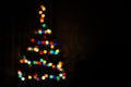 Christmas tree multicolored bokeh on dark background. Defocused multi colored lights. New Year, Christmas background Royalty Free Stock Photo