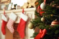 Christmas tree near fireplace with stockings indoors, closeup Royalty Free Stock Photo