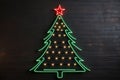 Christmas tree neon illuminated light on a dark wall