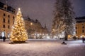 Christmas tree with new year holiday decoration in a city street at night, houses with lights, winter, snow Royalty Free Stock Photo