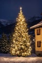 Christmas tree with new year holiday decoration in a city street at night, houses with lights, winter, snow Royalty Free Stock Photo